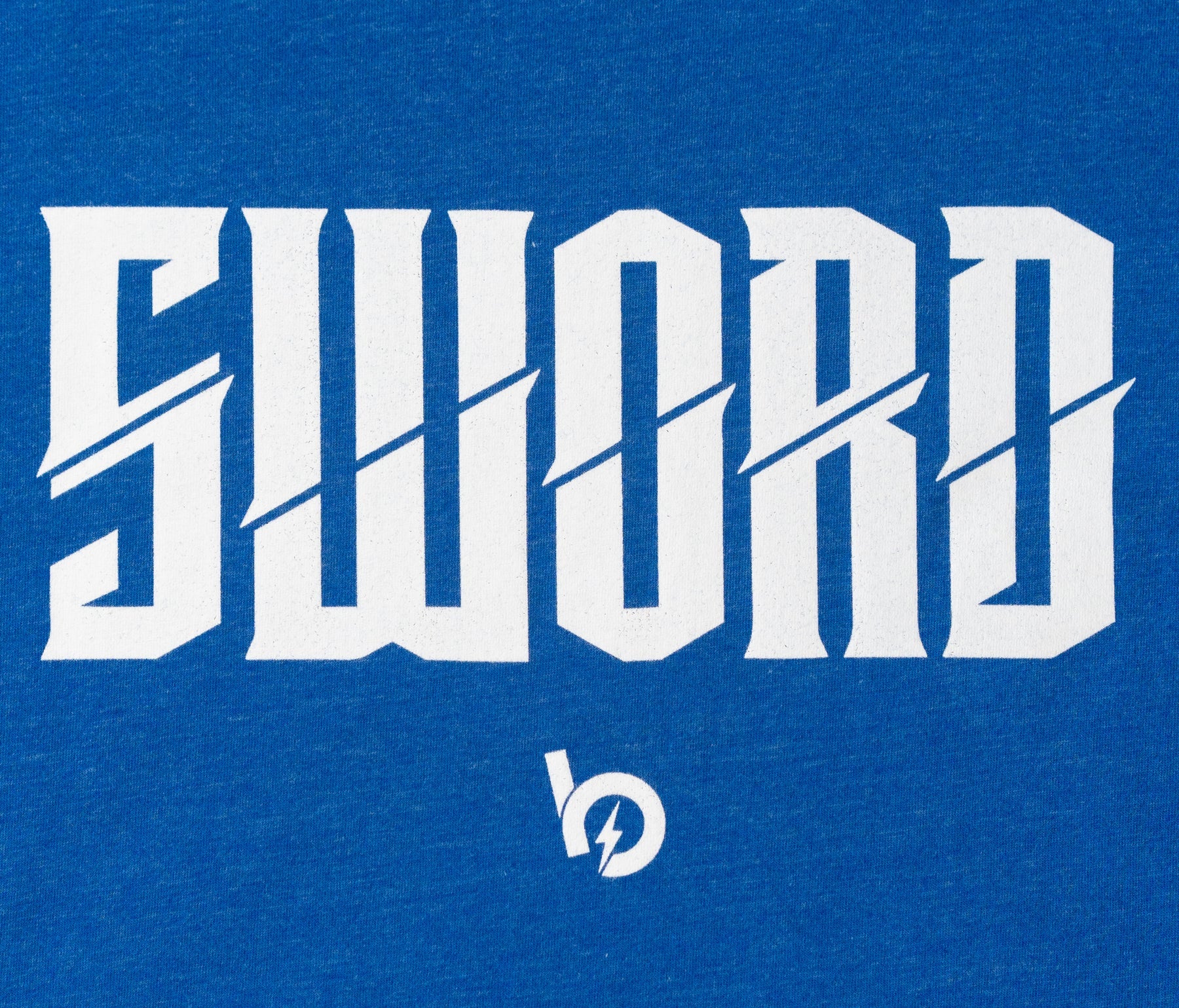 Close-up of the 'SWORD' logo on blue fabric, symbolizing strength and excellence in the Bauer Outage tee.