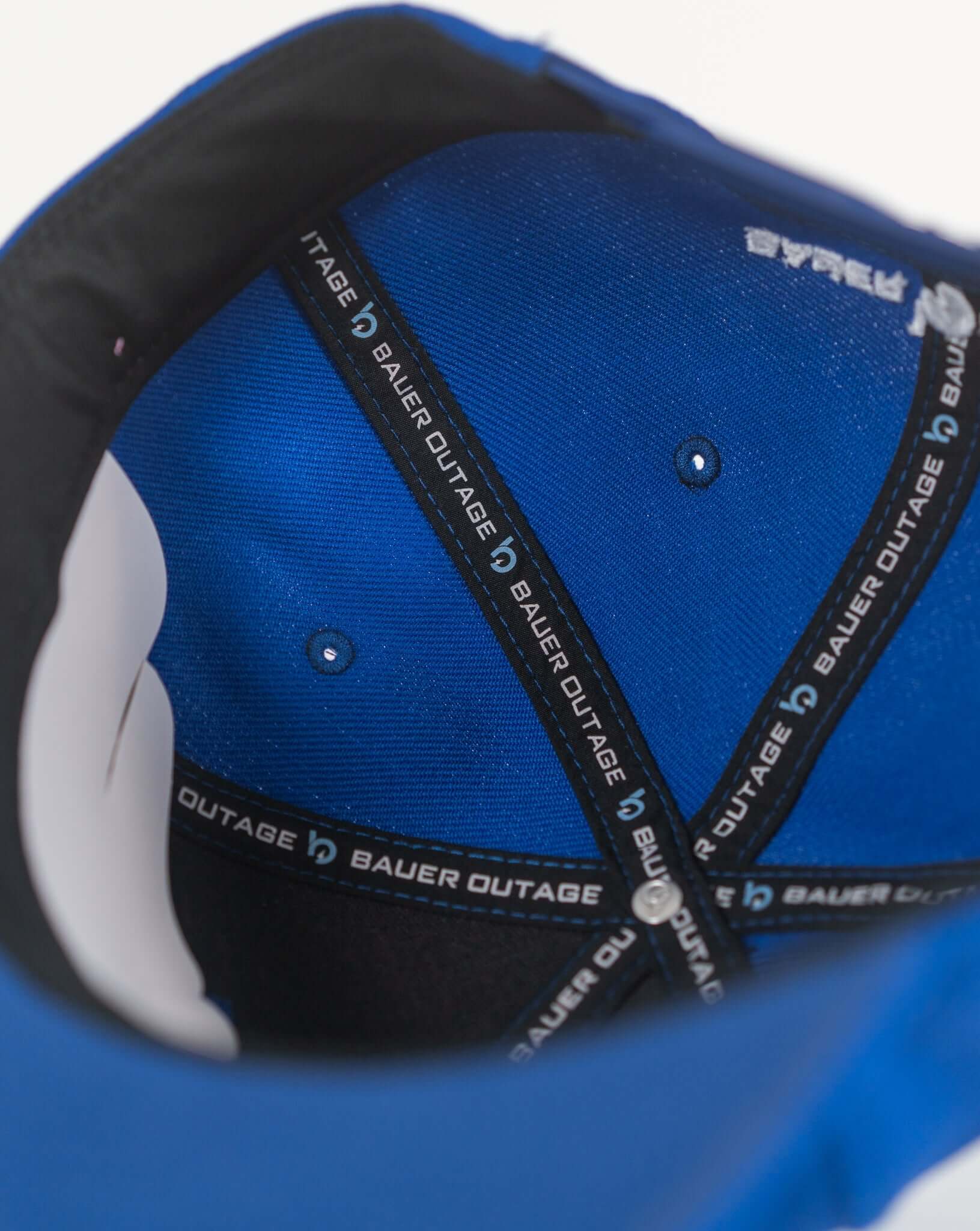 Interior view of the Bauer Outage Sword Snapback Hat showing blue fabric and branded inner lining.