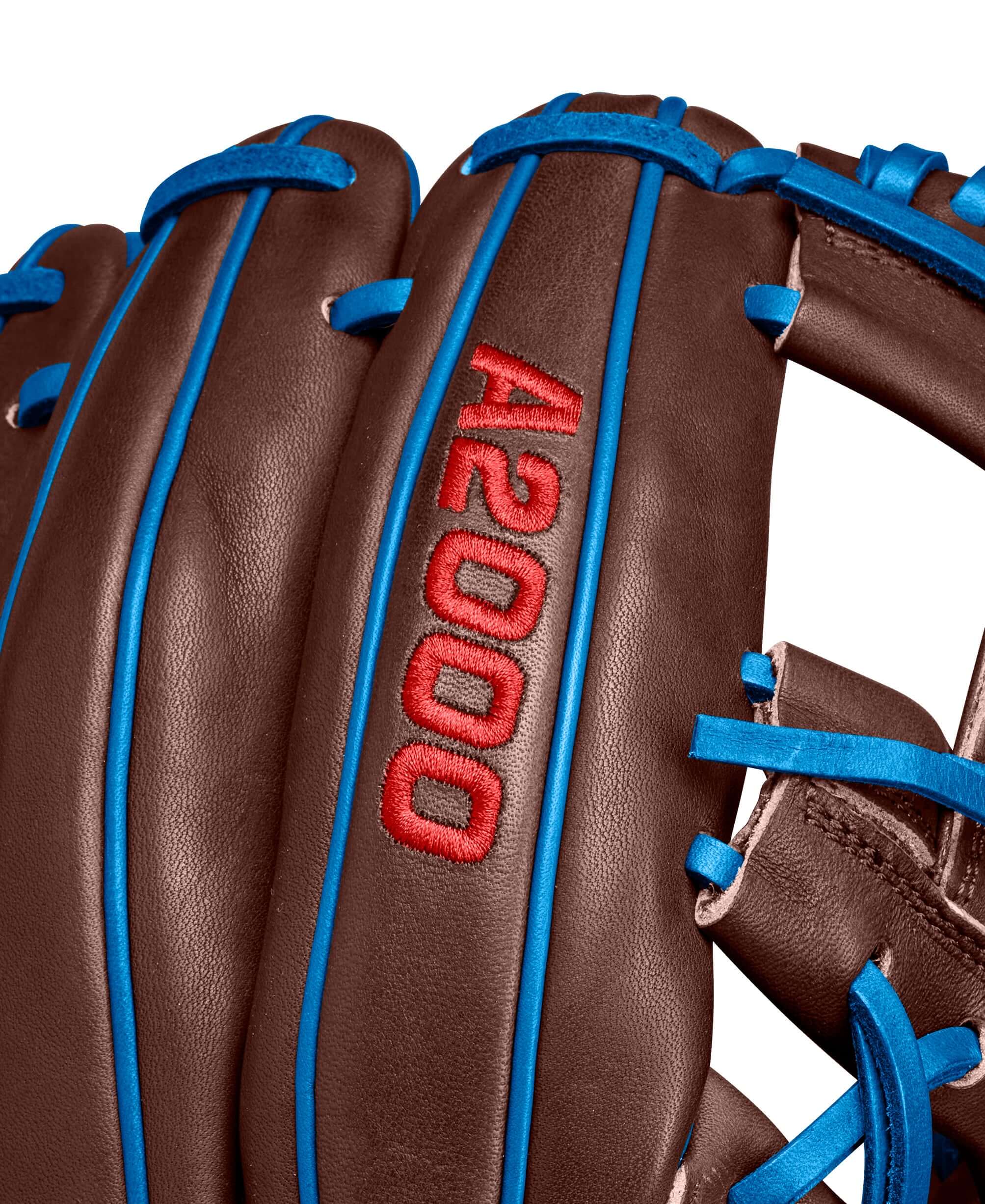 Close-up of Wilson A2000 Dansby Swanson GM glove, featuring brown leather and vibrant blue accents, Spring 2025 collection.