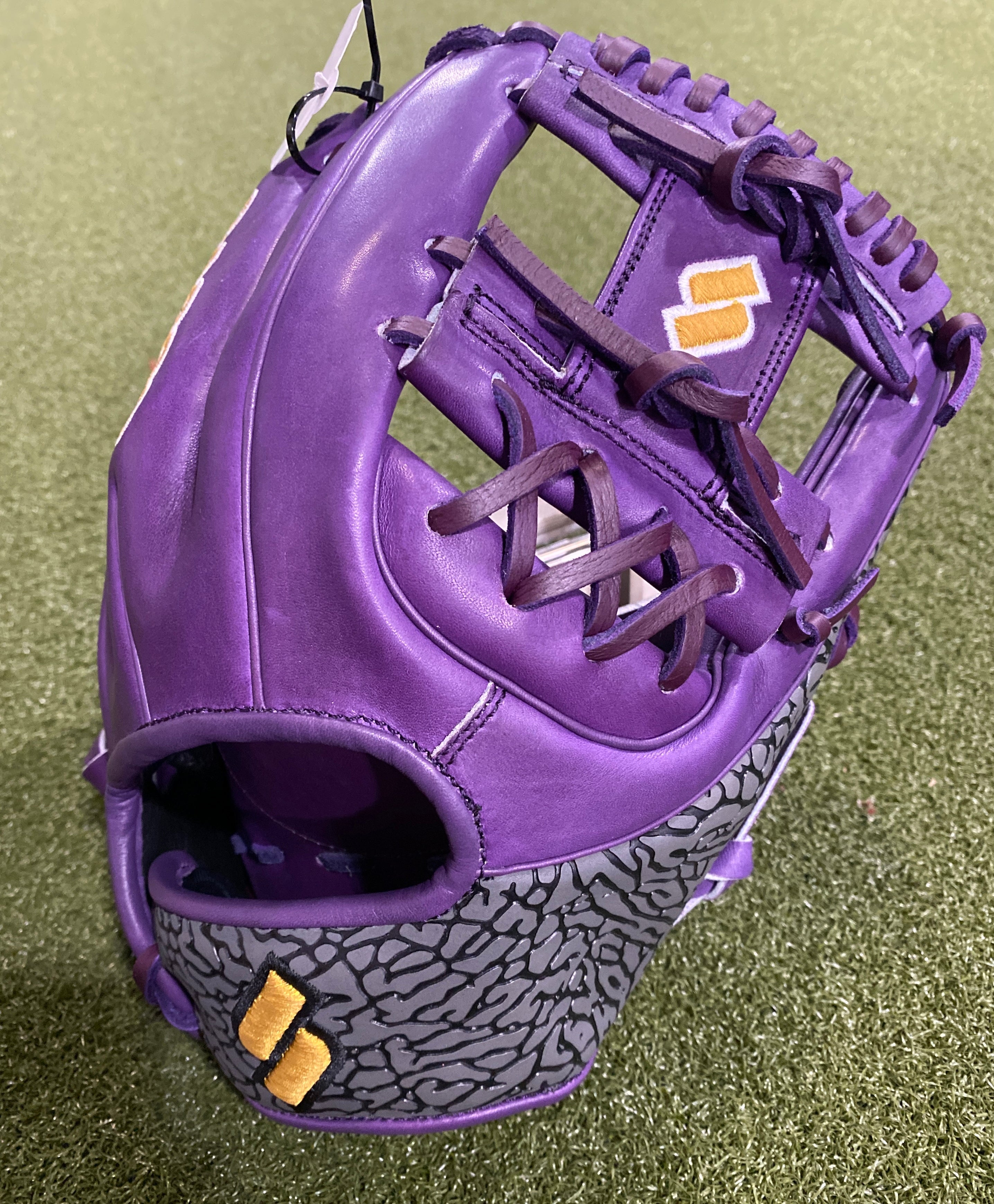 Purple Sacco Ultra Premium RHT I-Web 11.75" baseball glove with charcoal accents on grass field.