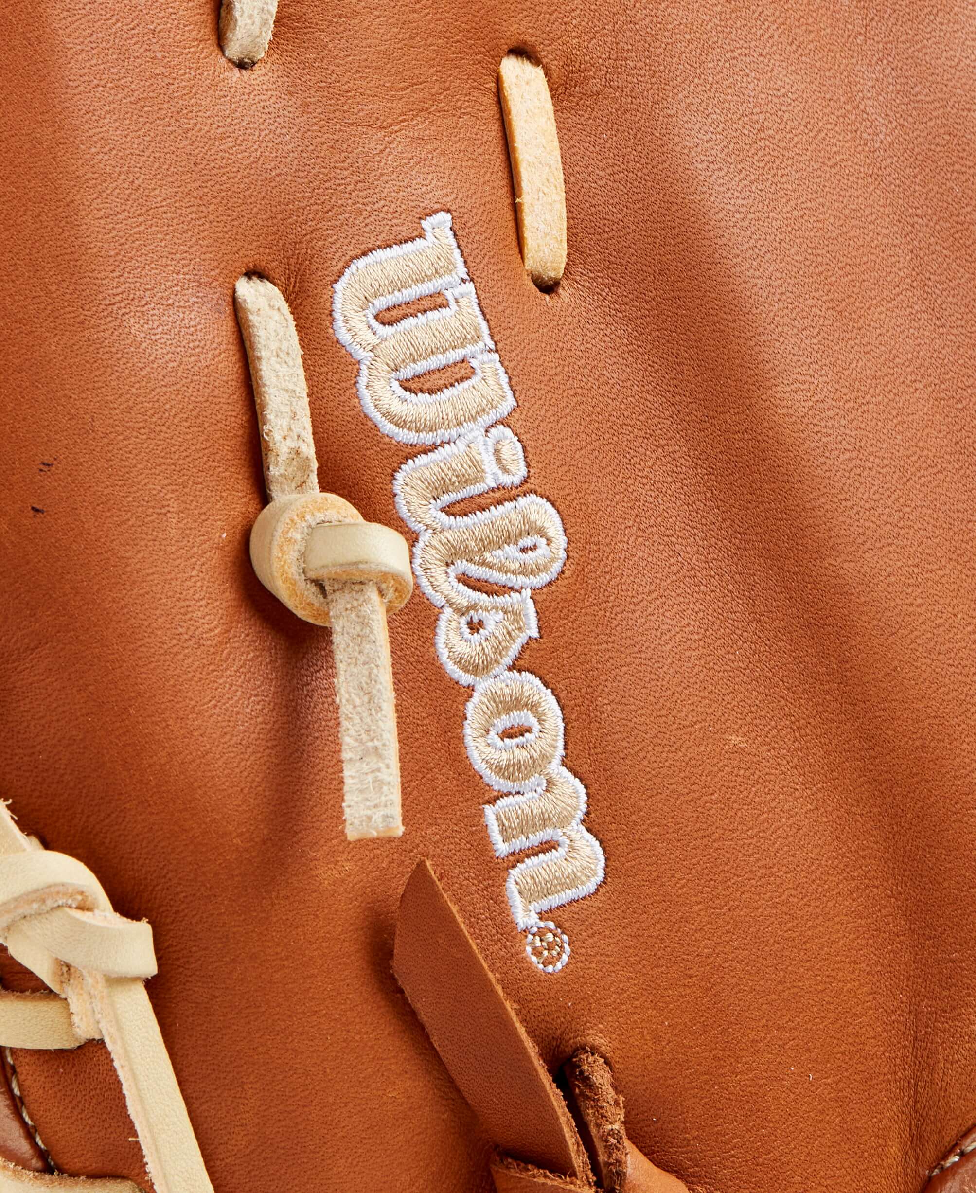 Close-up of Wilson logo on Saddle Tan Full Grain leather baseball mitt.