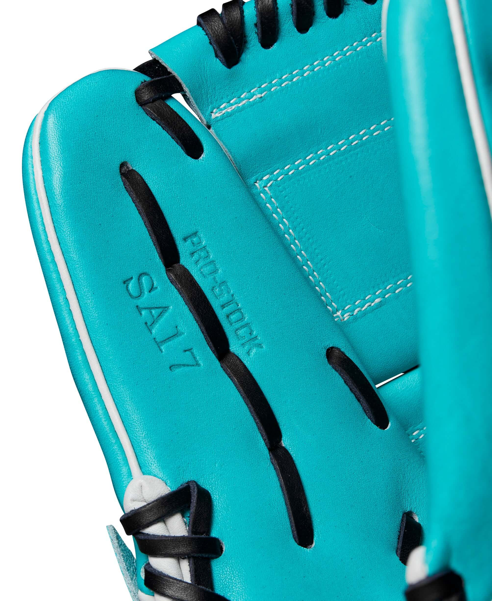 Close-up of Wilson A2000 SA17 baseball glove in teal and white, featuring pro stock leather and detailed stitching.