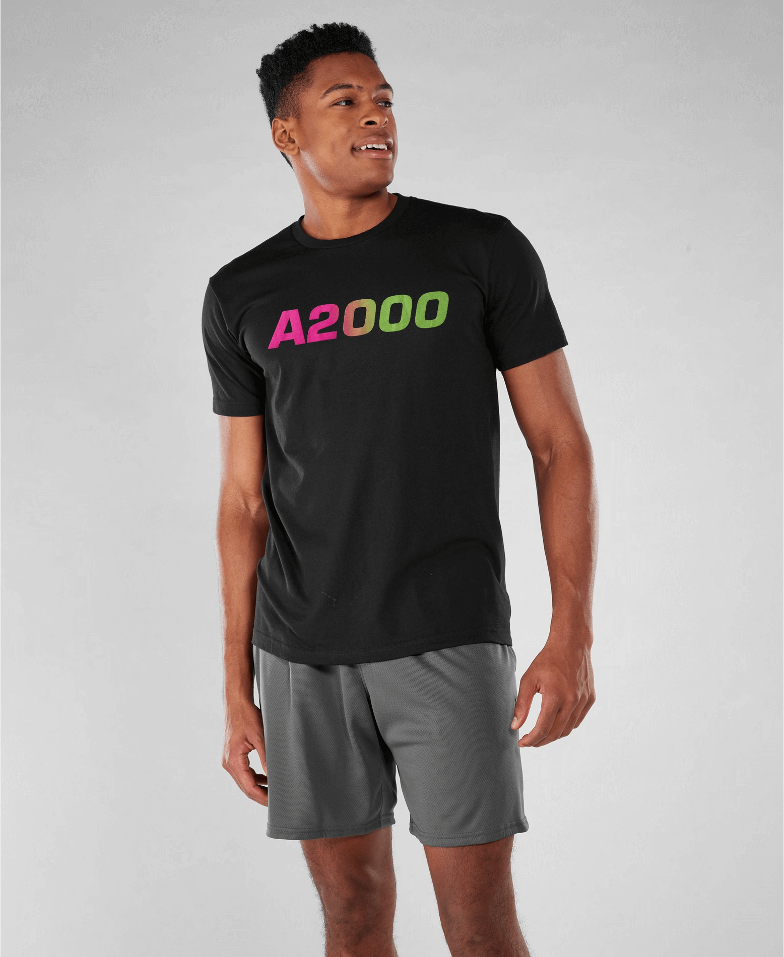 Man wearing Wilson Men's Neon A2000 Tee in black with flamingo pink and neon green logo, perfect for practice or casual wear.